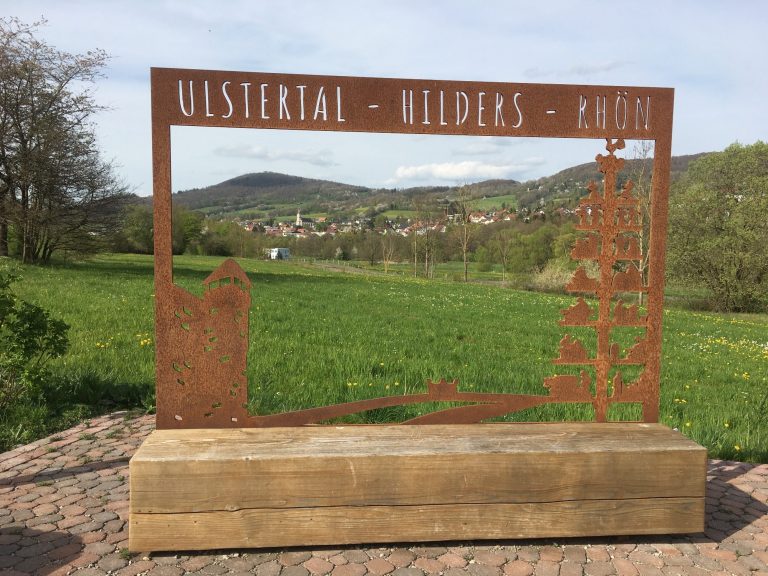 Sichtrahmen mit der Aufschrift „Ulstertal - Hilders - Rhön“, umgeben von Landschaft.